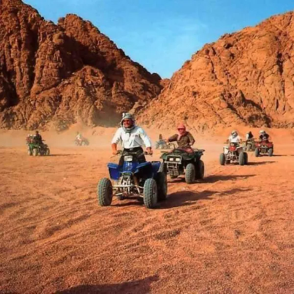 Tourist driving a beach buggy through Sinai dunes on a Dahab desert safari