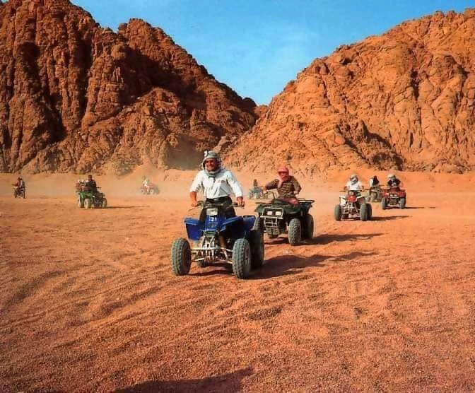 Tourist driving a beach buggy through Sinai dunes on a Dahab desert safari