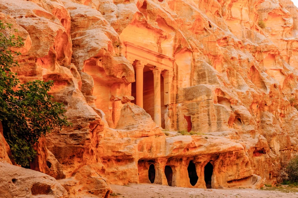 View of the rock-carved facades and narrow sandstone canyon of Little Petra, Jordan.