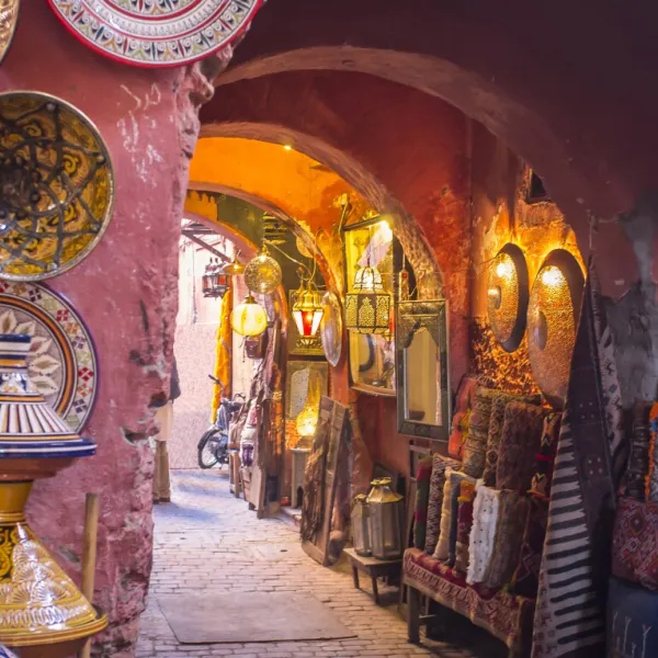 Colorful street in Marrakesh with traditional Moroccan architecture and bright market stalls.