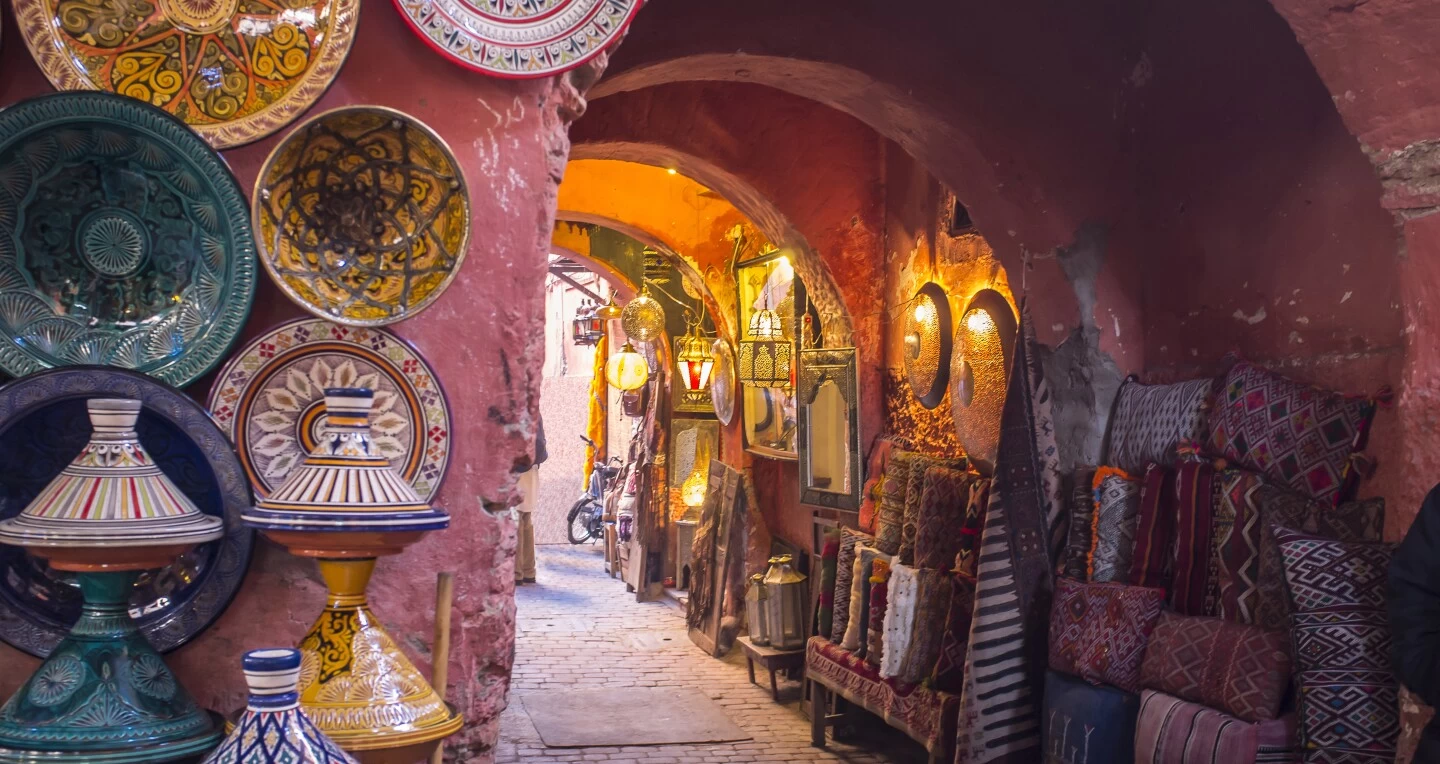 Colorful street in Marrakesh with traditional Moroccan architecture and bright market stalls.