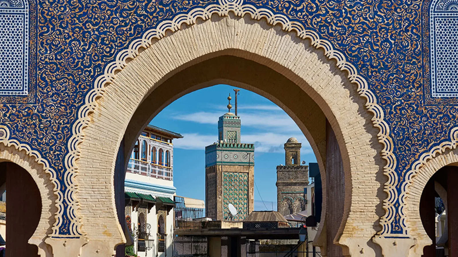 Moroccan riad interior in Fes with colorful tiles, arched doorways