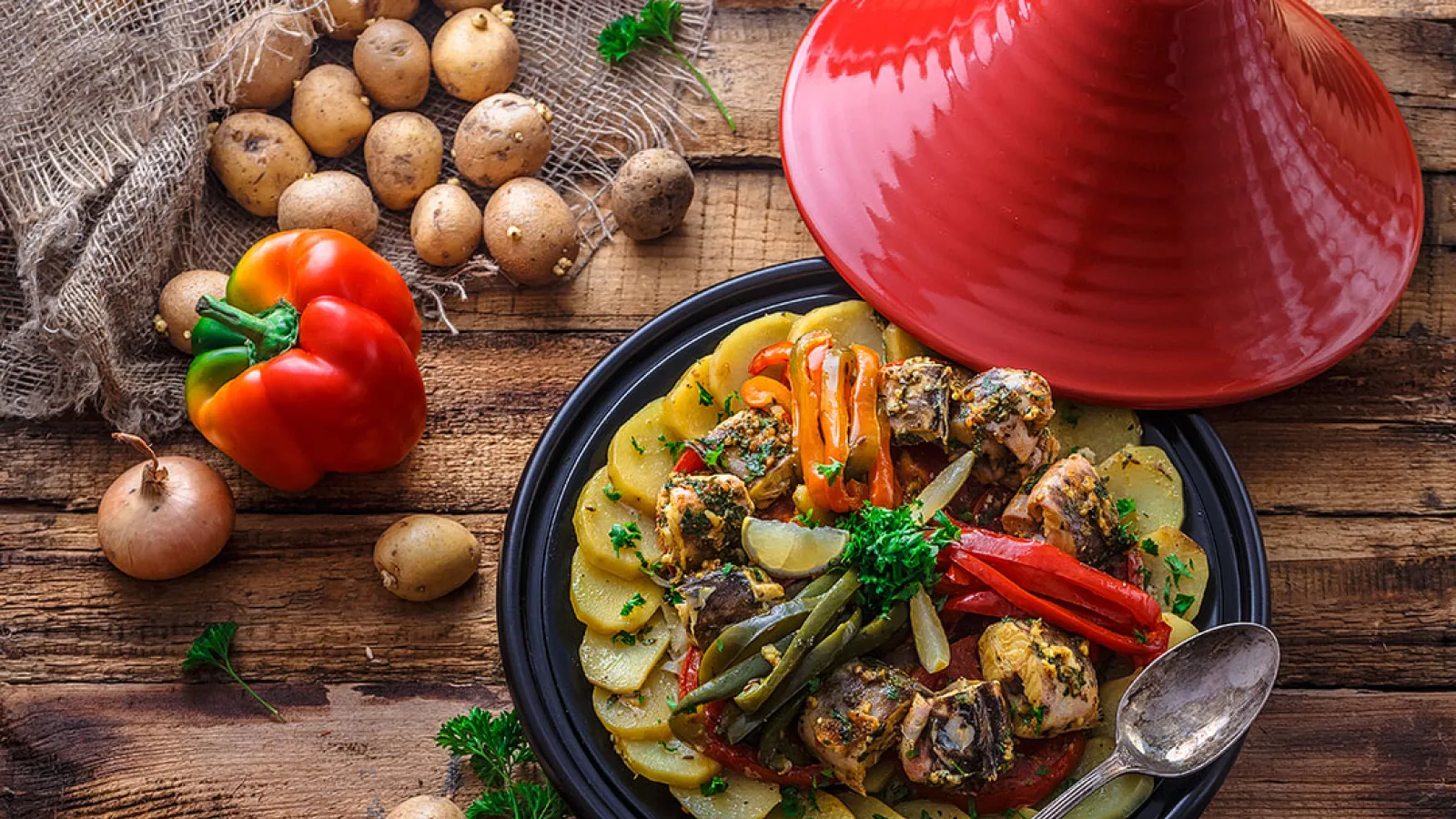 A Moroccan tagine served in a traditional clay plate with vibrant spices and vegetables