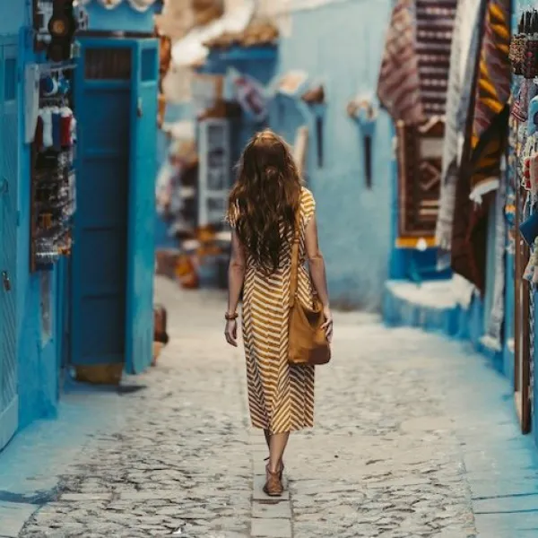 Traveler exploring the vibrant blue-painted streets of Chefchaouen, Morocco