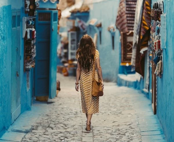 Traveler exploring the vibrant blue-painted streets of Chefchaouen, Morocco