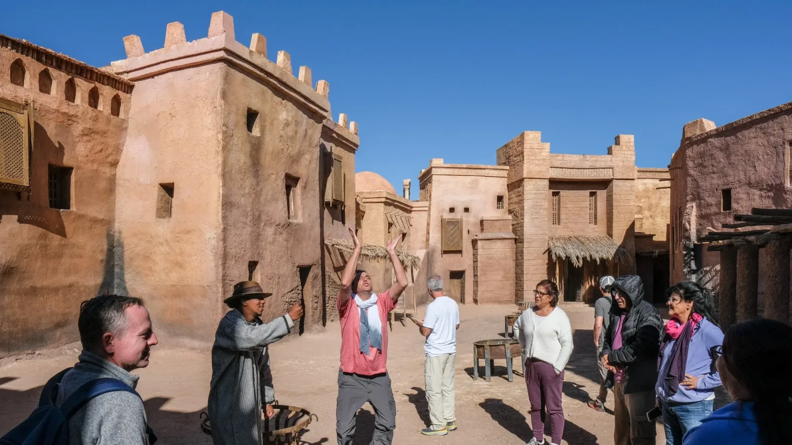 Tour group exploring Atlas Studios Morocco, walking through famous movie sets in Ouarzazate