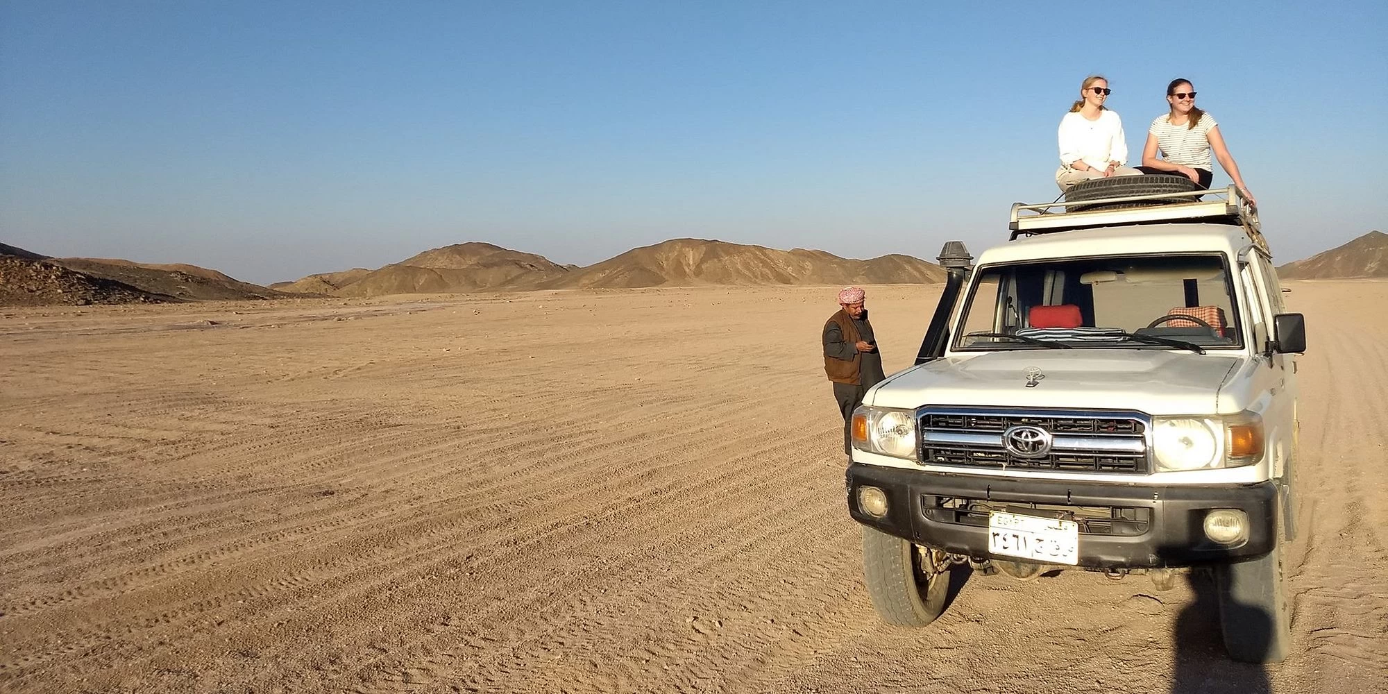 Tourists enjoying a 4x4 desert safari and camel ride in the Sinai Desert near Sharm El Sheikh, Egypt